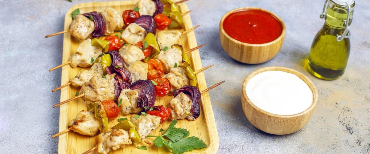 Chicken shish kebab with vegetables,ketchup,mayonnaise,top view