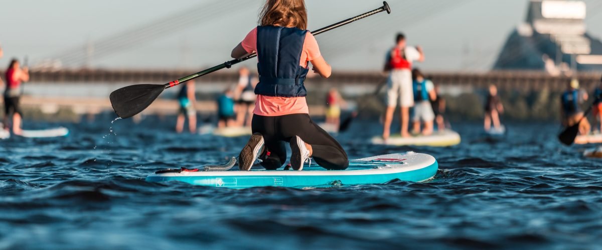 A female rowing with SUP paddle boards along the river