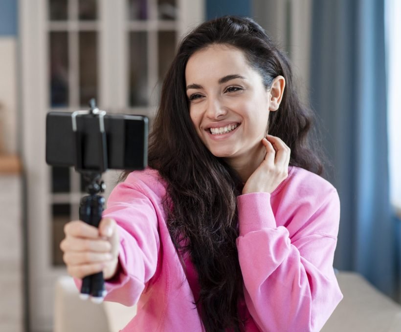 happy-young-blogger-using-selfie-stick-posing