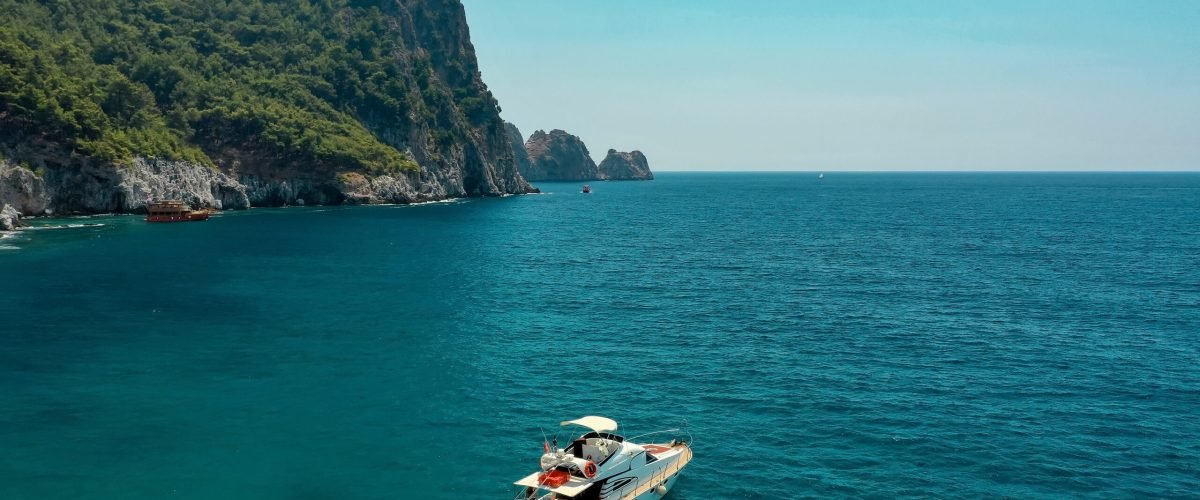 Sailboat in the sea in the evening sunlight over beautiful big mountains background, luxury summer adventure, active vacation in Mediterranean sea, Turkey